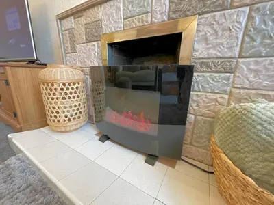 a living room with a stone wall with a fireplace at Pass the Keys Cosy Romantic Getaway with Hot Tub in Whithorn
