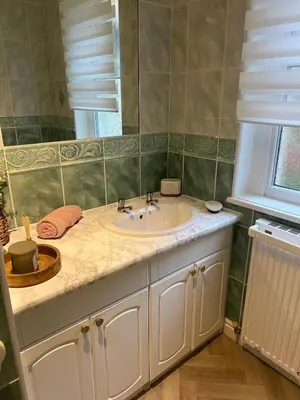 a bathroom with a white sink and a window at The Holm in Canonbie