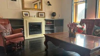 a living room with a table and a fireplace at Close to beaches and golf courses in Maybole