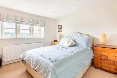 a bedroom with a large bed and a dresser at Woodlea Cottage in Moffat