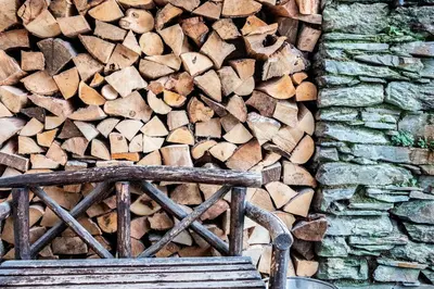 a pile of wood next to a stone wall at Victorian House in Grasmere