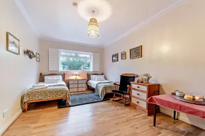 a bedroom with two beds and a table at 3 Bed in Kirkcolm oc-b34009 in Kirkcolm