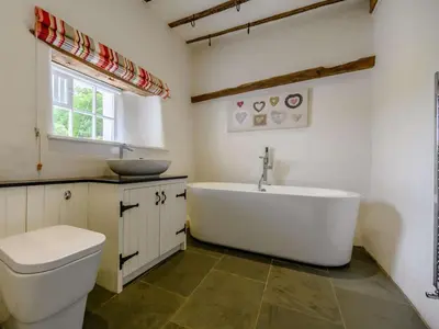 a bathroom with a tub and a sink and a toilet at 4 Bed in Nr Keswick oc-sz231 in Braithwaite