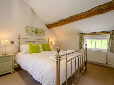 a bedroom with a large white bed with green pillows at 4 Bed in Nr Keswick oc-sz231 in Braithwaite