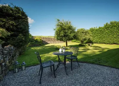 a table and two chairs on a gravel patio at 1 Bed in Uldale oc-g34032 in Uldale