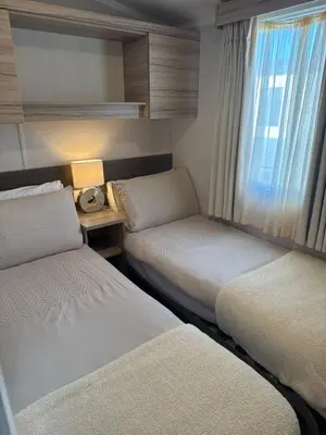 a hotel room with two beds and a window at Luxury Seafront 3 Bedroom Caravan in Minishant