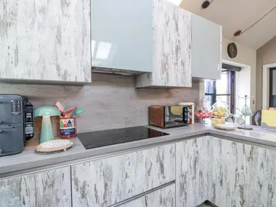 a kitchen with white wooden cabinets and a microwave at Scotia At The Brig in Annan