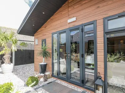 a house with sliding glass doors on it at Cabin At The Brig in Annan