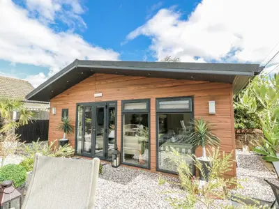 a tiny house with sliding glass doors at Cabin At The Brig in Annan