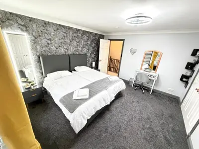 a bedroom with a large white bed and a desk at Seaside Retreat in Harrington