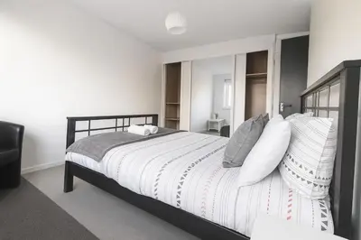 a bedroom with a large bed with white sheets and pillows at 3 Bedroom Cozy House-Short and Long Stay in Moffat
