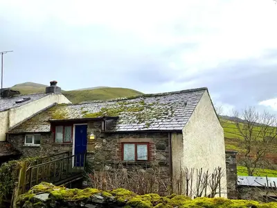 an old stone house with a blue door at 2 Bed in Wigton oc-b34112 in Caldbeck