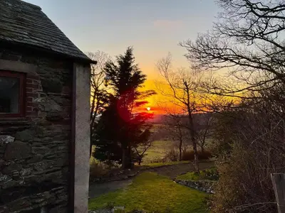 a sunset seen through a door of a stone building at 2 Bed in Wigton oc-b34112 in Caldbeck