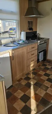 a kitchen with a stove and a checkered floor at Montrose No3 - Turnberry Holiday Park in Turnberry