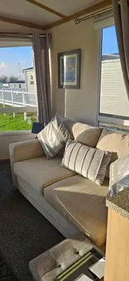 a couch in a living room with a large window at Montrose No3 - Turnberry Holiday Park in Turnberry