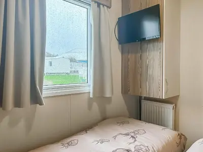 a small room with a bed and a window at Kjs Holiday Haven in Ayr