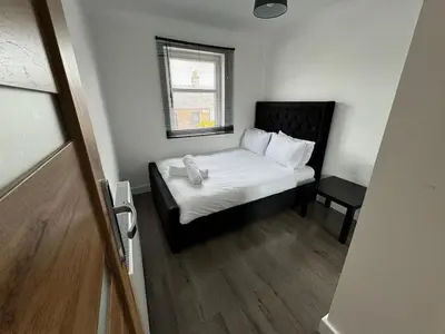 a small bedroom with a bed and a window at 3 bedroom luxury Apartment in Prestwick