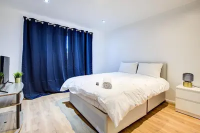 a bedroom with a large bed with blue curtains at Southend perfect Stays in Moffat