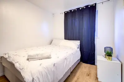a bedroom with a bed with a blue curtain at Southend perfect Stays in Moffat