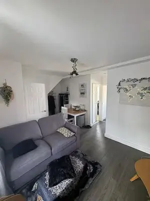 a living room with a purple couch and a kitchen at Private Room in Berkhamsted high street in Moffat