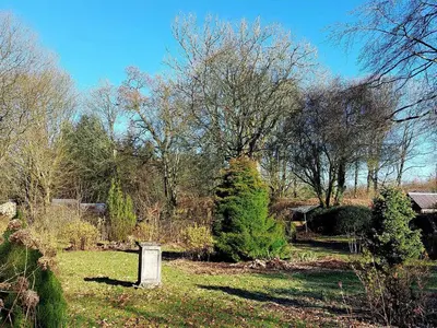 a cemetery with a tombstone and trees in a field at The Coach House- Canonbie in Canonbie