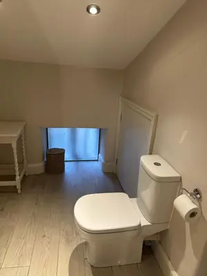 a bathroom with a white toilet and a sink at The Oldest House Located in the heart of Matlock in Moffat