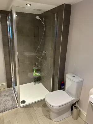 a bathroom with a shower with a white toilet at The Oldest House Located in the heart of Matlock in Moffat