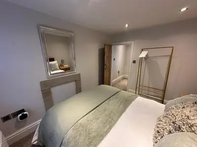 a small bedroom with a bed and a mirror at The Oldest House Located in the heart of Matlock in Moffat