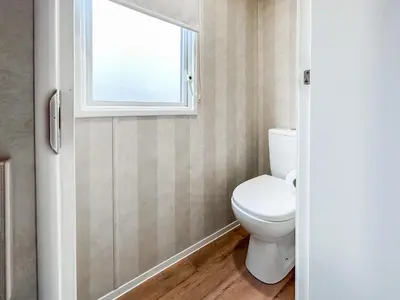 a bathroom with a toilet and a window at H And D Greenan Village in Ayr