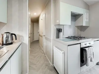 a kitchen with white cabinets and a stove at H And D Greenan Village in Ayr