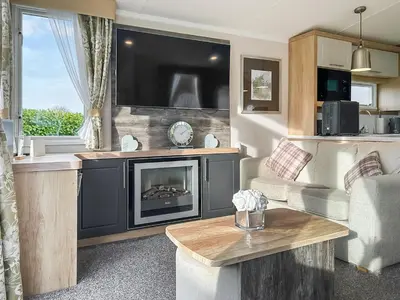 a living room with a fireplace and a tv at Rorys Retreat - Ukc7144 in Ayr