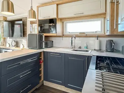 a kitchen with blue cabinets and a sink at Rorys Retreat - Ukc7144 in Ayr