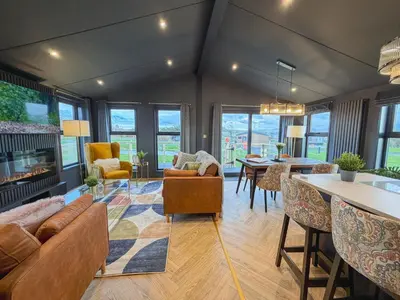 a living room with a couch and chairs and a table at Blackthorn Timber Lodge in Bothel