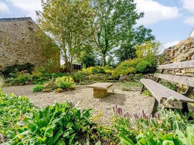 a wooden bench sitting in the middle of a garden at 2 Bed in Eaglesfield 85288 in Eaglesfield