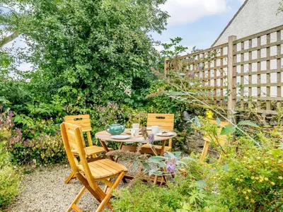 a patio with two chairs and a table in a garden at 2 Bed in Eaglesfield 85288 in Eaglesfield