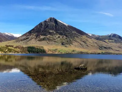 a mountain sitting on top of a body of water at 2 Bed in Eaglesfield 85288 in Eaglesfield