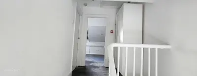 a hallway with white walls and a stair case at The Spacious Urban Retreat in Douglas