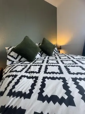 a blue and white bed with two pillows on it at West Lakes 3 Bedroom - Sleeps 5 - Self Check In - Fully Furnished House in Workington