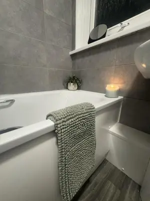 a bathroom with a white bath tub and a sink at West Lakes 3 Bedroom - Sleeps 5 - Self Check In - Fully Furnished House in Workington