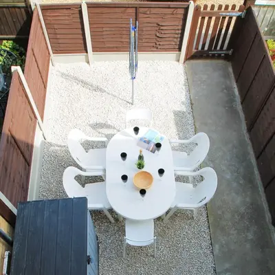 an overhead view of a table and chairs on a patio at Beach Stroll Retreat, Swanage, Dorset in Moffat