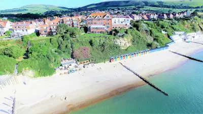 an aerial view of a beach with a group of people at Beach Stroll Retreat, Swanage, Dorset in Moffat