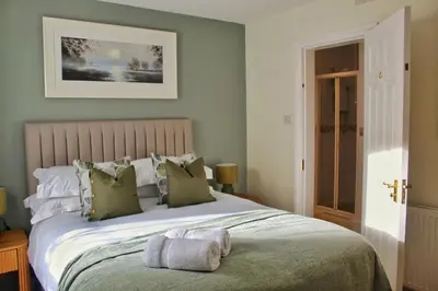 a bedroom with a large bed with green walls at Azalea in Keswick