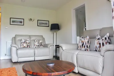 a living room with two couches and a coffee table at Azalea in Keswick