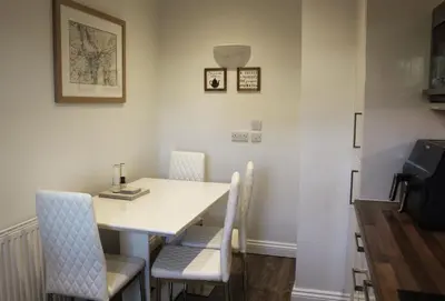 a dining room with a white table and chairs at Azalea in Keswick