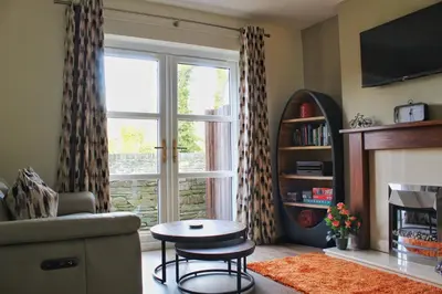 a living room with a large window and a table at Azalea in Keswick