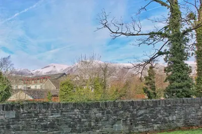 a stone retaining wall with mountains in the background at Azalea in Keswick