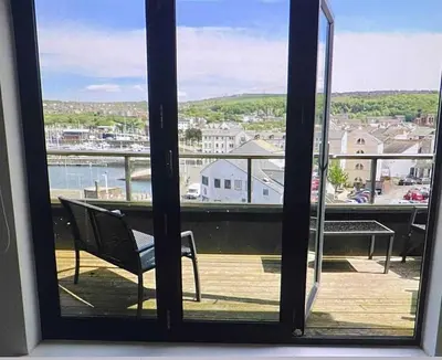 a window with a view of a balcony with a chair at Bardywell Penthouse - 2 Bedrooms - Sleeps 4 in Whitehaven