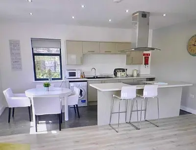 a kitchen with a table and some white chairs at Bardywell Penthouse - 2 Bedrooms - Sleeps 4 in Whitehaven