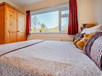 a bedroom with a bed with a teddy bear on it at Blengfell by Prestige Properties SA in Gosforth