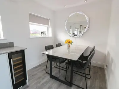 a dining room with a table and chairs and a mirror at Marchdyke Farm Cottage in Lockerbie